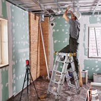 Room repair. Interior finish. young builder makes a plasterboard ceiling, standing on a stepladder